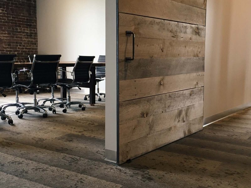 Meeting room with wood floors and a barn door